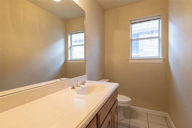 bathroom with tile patterned floors, a wealth of natural light, vanity, and toilet