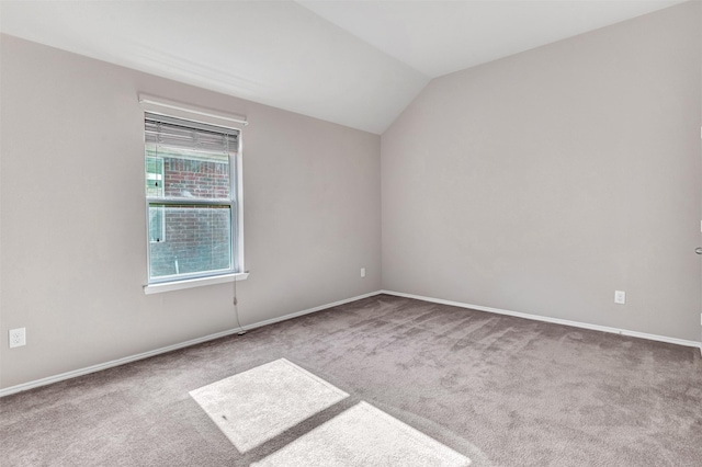 spare room with carpet and lofted ceiling