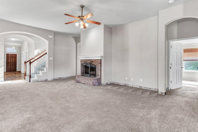 unfurnished living room featuring carpet, ceiling fan, and a fireplace