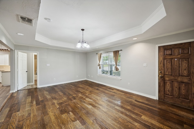 foyer entrance featuring dark hardwood / wood-style flooring, a raised ceiling, and ornamental molding