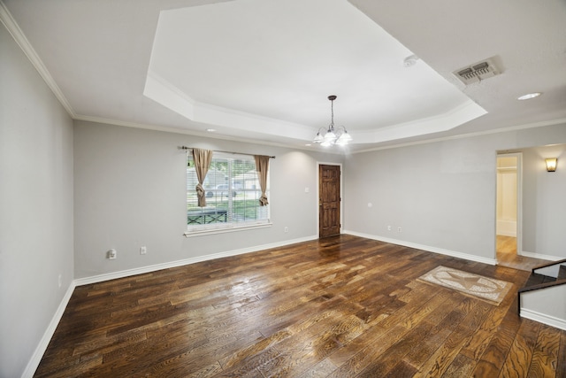 unfurnished living room featuring a raised ceiling, crown molding, dark wood-type flooring, and a notable chandelier