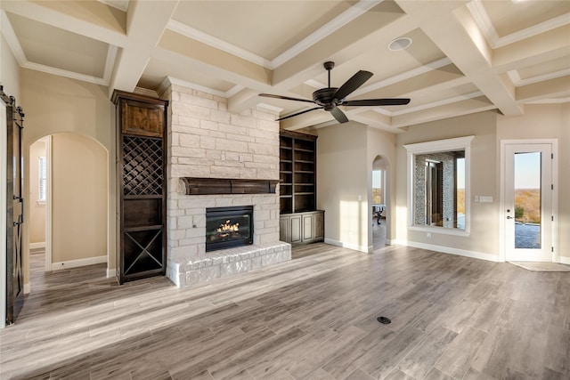 unfurnished living room with light hardwood / wood-style flooring, ceiling fan, ornamental molding, and coffered ceiling