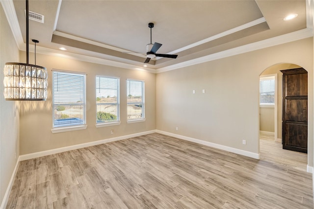 unfurnished room with ceiling fan, light hardwood / wood-style floors, crown molding, and a tray ceiling