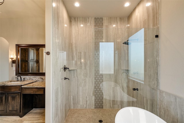 bathroom with vanity and shower with separate bathtub