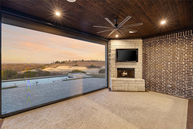 interior space with ceiling fan and an outdoor stone fireplace