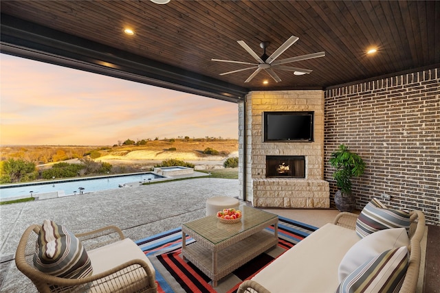 view of patio / terrace featuring an outdoor living space with a fireplace and ceiling fan