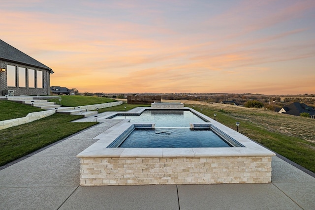 pool at dusk featuring a lawn