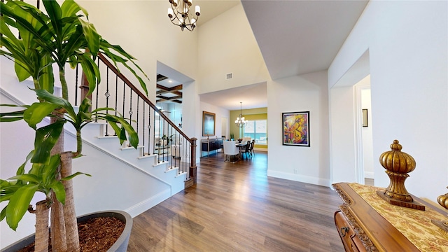 entrance foyer with a notable chandelier, dark hardwood / wood-style flooring, and a high ceiling