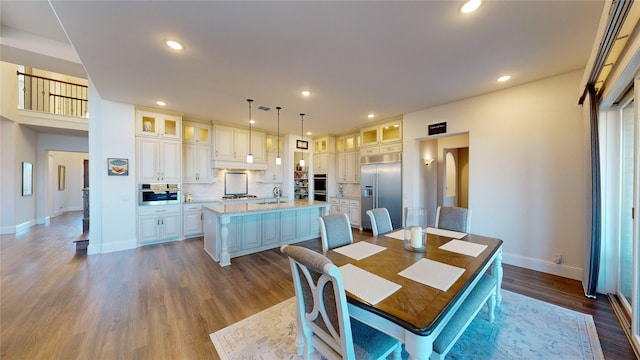 dining area featuring sink and dark wood-type flooring