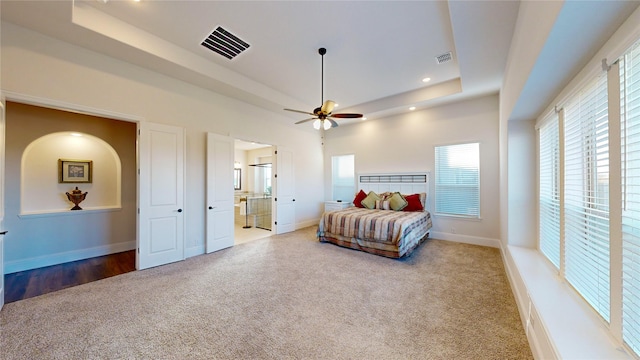 bedroom featuring carpet, ceiling fan, and a raised ceiling