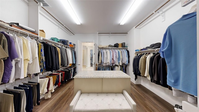 walk in closet with dark hardwood / wood-style flooring