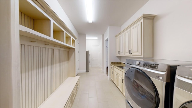 laundry room with washing machine and dryer and cabinets