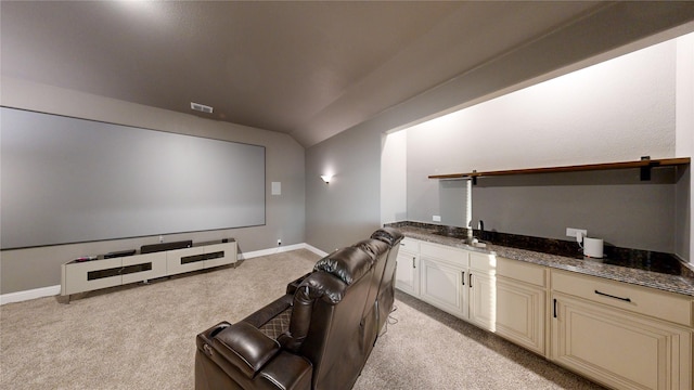 cinema room featuring light colored carpet, vaulted ceiling, and sink