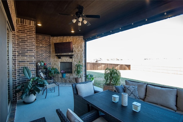 view of patio featuring ceiling fan and an outdoor stone fireplace