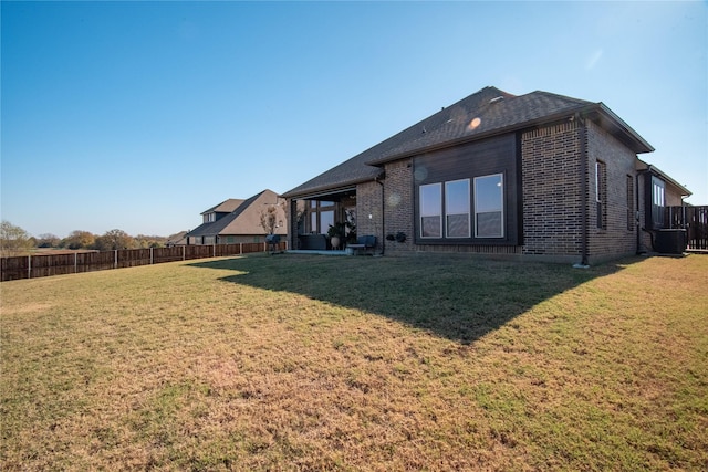 back of property with a yard and central air condition unit