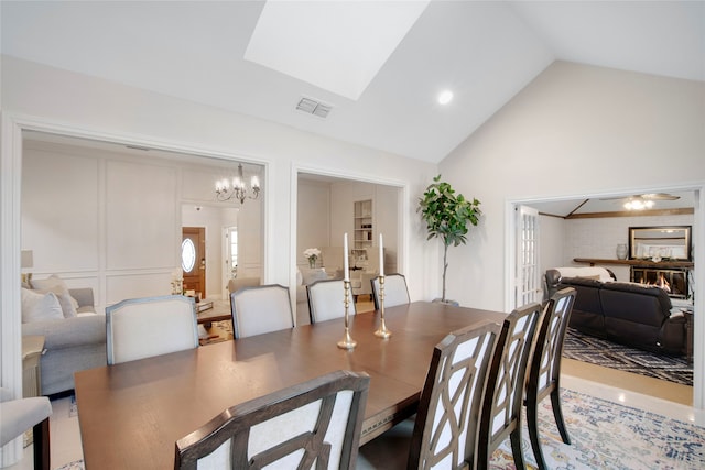 dining space featuring high vaulted ceiling and an inviting chandelier