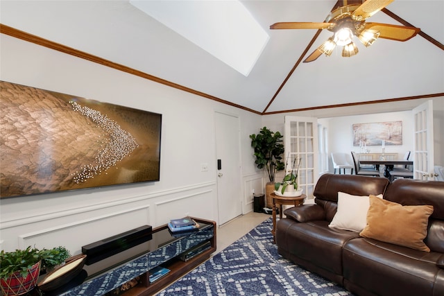 living room with ceiling fan, light hardwood / wood-style floors, ornamental molding, and vaulted ceiling