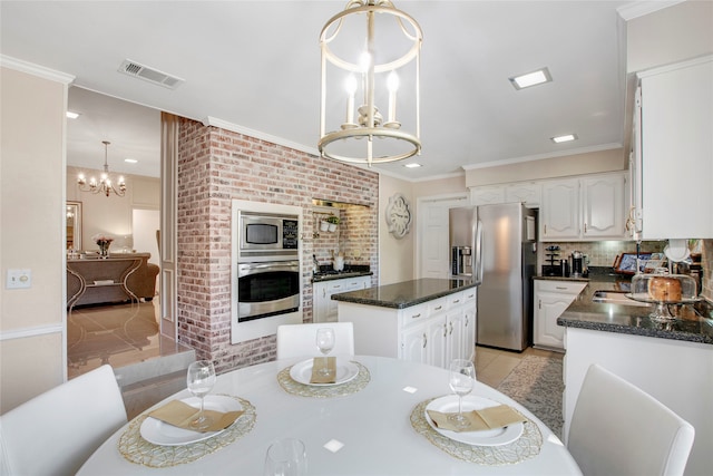 dining space with a chandelier, sink, light hardwood / wood-style floors, and ornamental molding