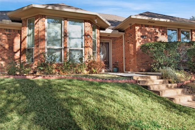 view of exterior entry with a yard