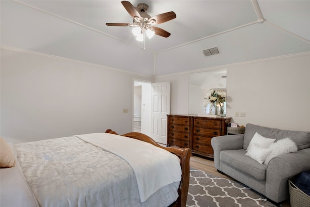 bedroom featuring light wood-type flooring, crown molding, ceiling fan, and lofted ceiling