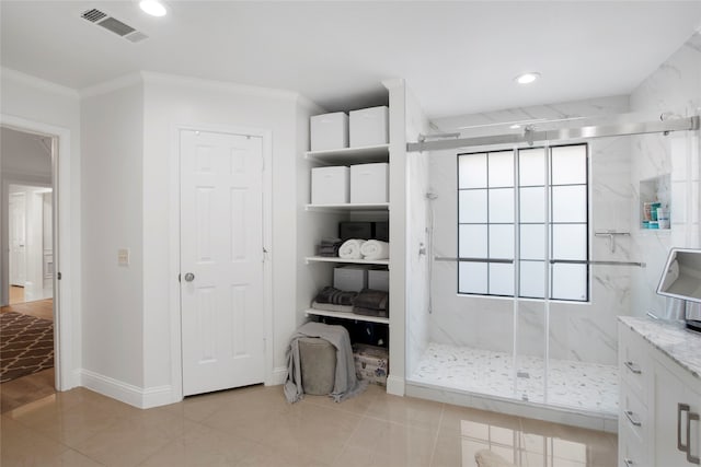 bathroom featuring tile patterned floors, vanity, ornamental molding, and walk in shower