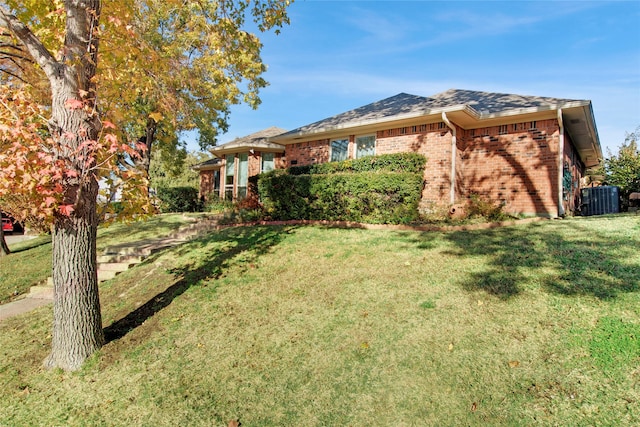 ranch-style house with a front lawn and cooling unit