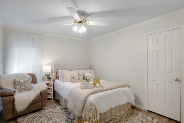 bedroom featuring ceiling fan, ornamental molding, and hardwood / wood-style flooring