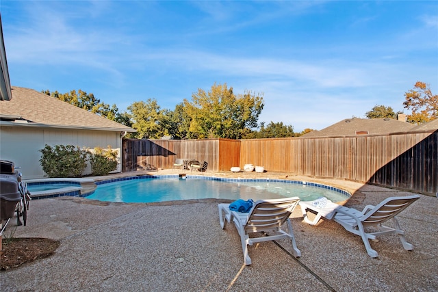 view of swimming pool featuring a patio area and an in ground hot tub