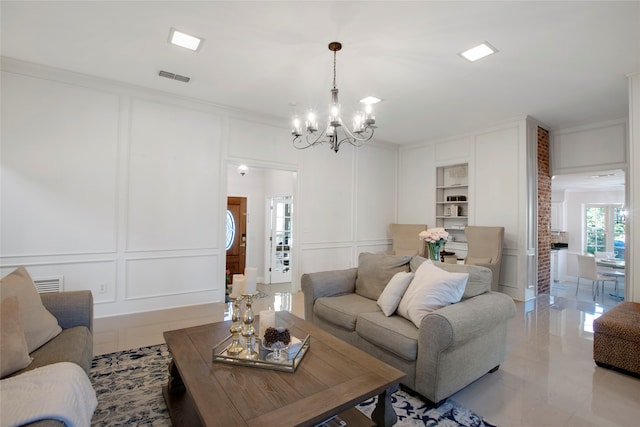 tiled living room featuring built in features, crown molding, and a chandelier