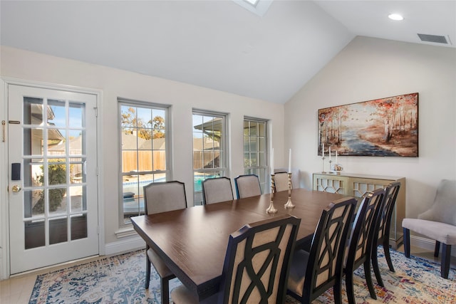 dining area with light tile patterned floors and vaulted ceiling