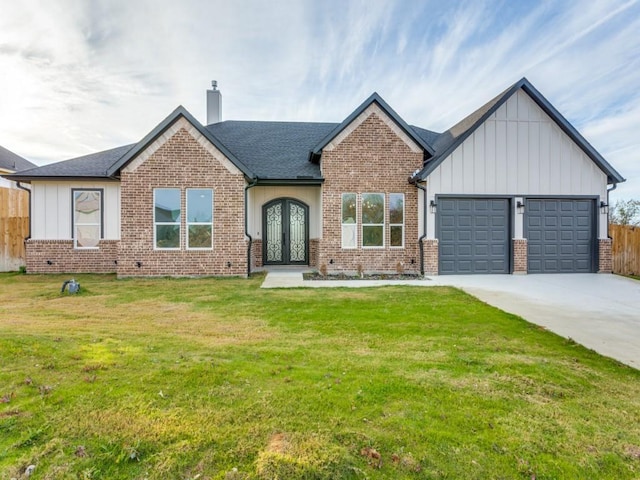 view of front facade featuring french doors, a front yard, and a garage