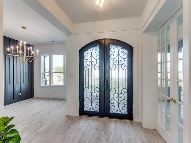 entryway featuring a chandelier, french doors, and hardwood / wood-style flooring