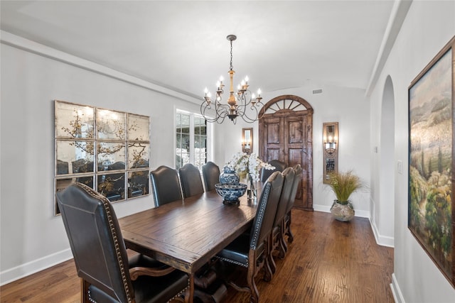 dining room with dark wood-type flooring and a notable chandelier