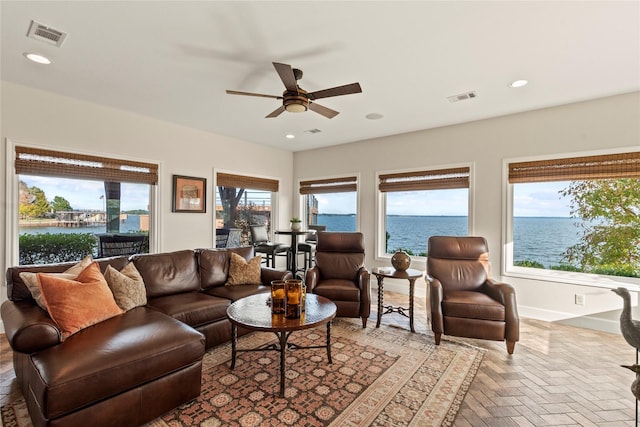 living room featuring a water view, a wealth of natural light, and ceiling fan