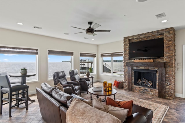 living room featuring ceiling fan and a fireplace