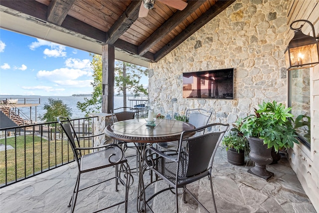 view of patio featuring ceiling fan and a water view