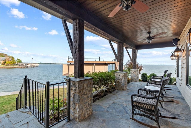 view of patio / terrace with ceiling fan and a water view