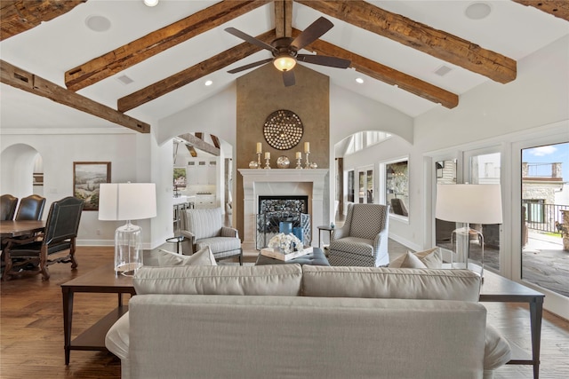 living room featuring a wealth of natural light, beamed ceiling, high vaulted ceiling, and wood-type flooring