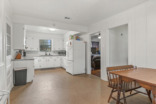 kitchen with sink, tasteful backsplash, white fridge, white cabinets, and ornamental molding