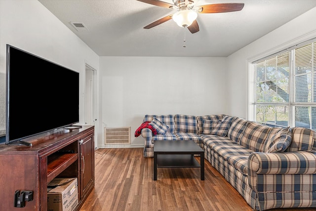 living room featuring ceiling fan, hardwood / wood-style floors, and a textured ceiling