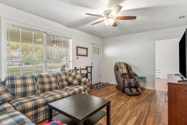 living room featuring ceiling fan, wood-type flooring, and a textured ceiling