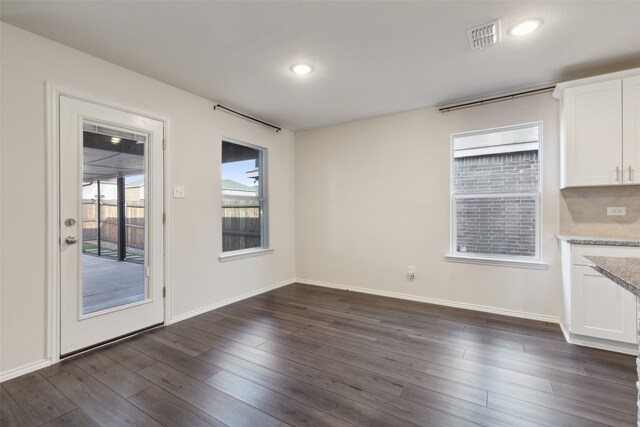 unfurnished dining area featuring dark hardwood / wood-style floors