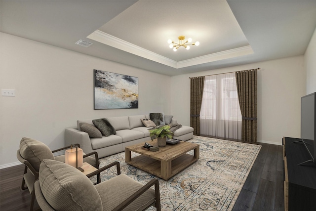 living room featuring a chandelier, dark hardwood / wood-style floors, a raised ceiling, and ornamental molding