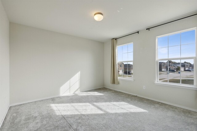 unfurnished room featuring light carpet