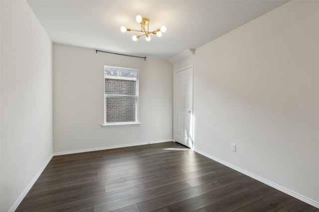 empty room with dark hardwood / wood-style floors and an inviting chandelier