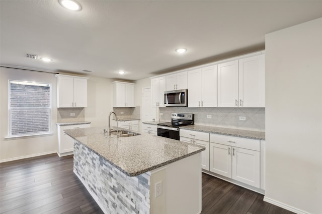 kitchen with white cabinets, stainless steel appliances, light stone counters, and sink