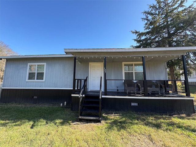 manufactured / mobile home with covered porch and a front yard