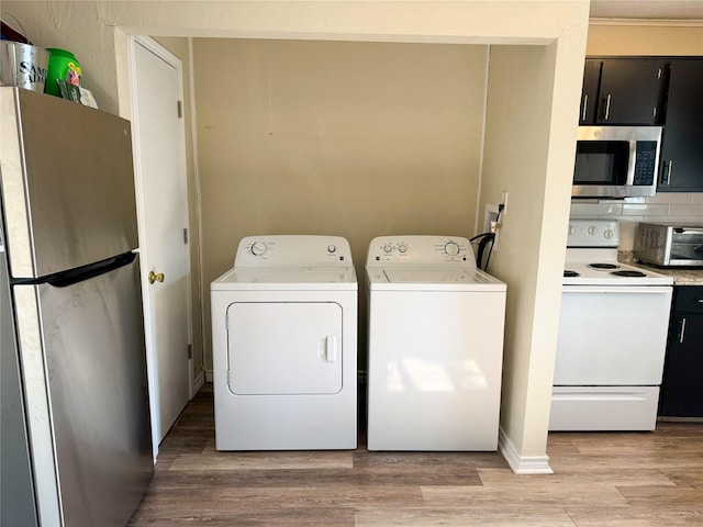 laundry area featuring separate washer and dryer and light hardwood / wood-style flooring