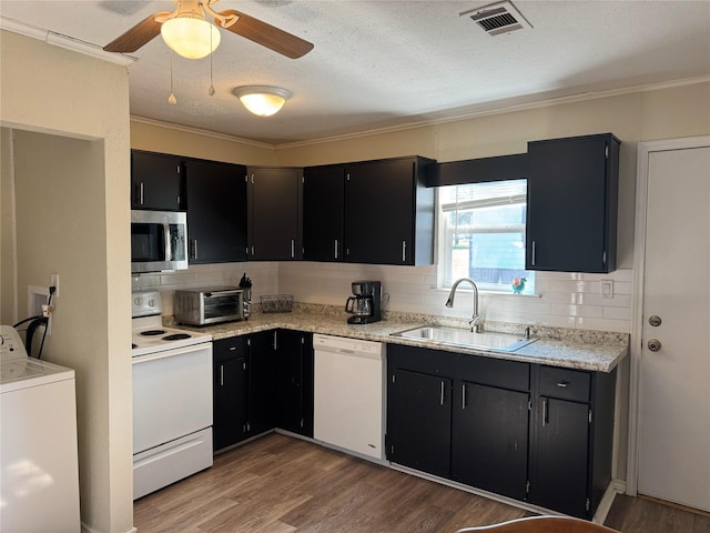 kitchen featuring tasteful backsplash, white appliances, sink, washer / dryer, and dark hardwood / wood-style floors