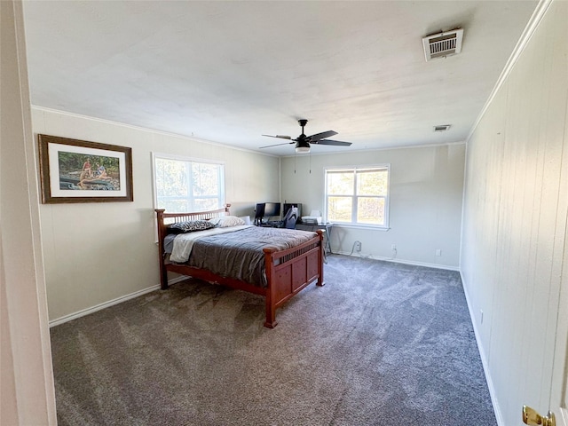 bedroom featuring ceiling fan, dark carpet, ornamental molding, and multiple windows